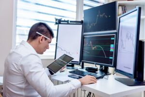 Investitor îngrijorat privind un grafic financiar în scădere pe ecran, analizând cele 3 faze pentru a înțelege până unde scade bursa.